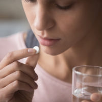 Close,Up,Cropped,Image,Millennial,Mixed,Race,Girl,Holding,Pill