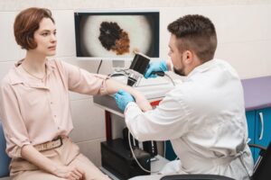 Male,Doctor,Examines,Neoplasms,Or,Moles,On,The,Woman,Patient's