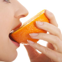 Close,Up,On,Woman,Eating,An,Orange.